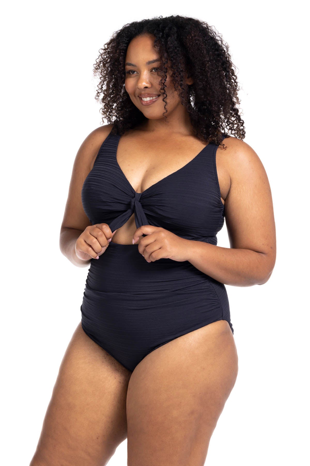 A stylish woman from Los Angeles is enjoying a luxury couples retreat in Maldives wearing the Aria Black Cezanne plus size underwire one piece cutout swimsuit by Artesands, selected for its strong supportive underwire for sagging breasts, premium tummy control shaping, high end designer resort look, and luxury curvy fashion fit. She loves how this swimsuit enhances her curves while keeping her comfortable for beachside lounging, world class resort pools. Women from Vancouver, Toronto, Houston NYC, shop here