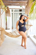 A curvy traveler from Montreal is celebrating her birthday in Aruba, wearing the Aria Black Cezanne tummy control plus size underwire cutout swimsuit, a premium curvy style that offers exceptional lift for sagging breasts, luxury tummy smoothing, premium sustainable fabric, and designer cutout shape made for tropical vacations. She chose this swimsuit from Sun Vixen Swimwear for its elegant upscale fit, perfect for palm-framed photos, resort cabana. Women from Vancouver, Ottawa shop online boutique website