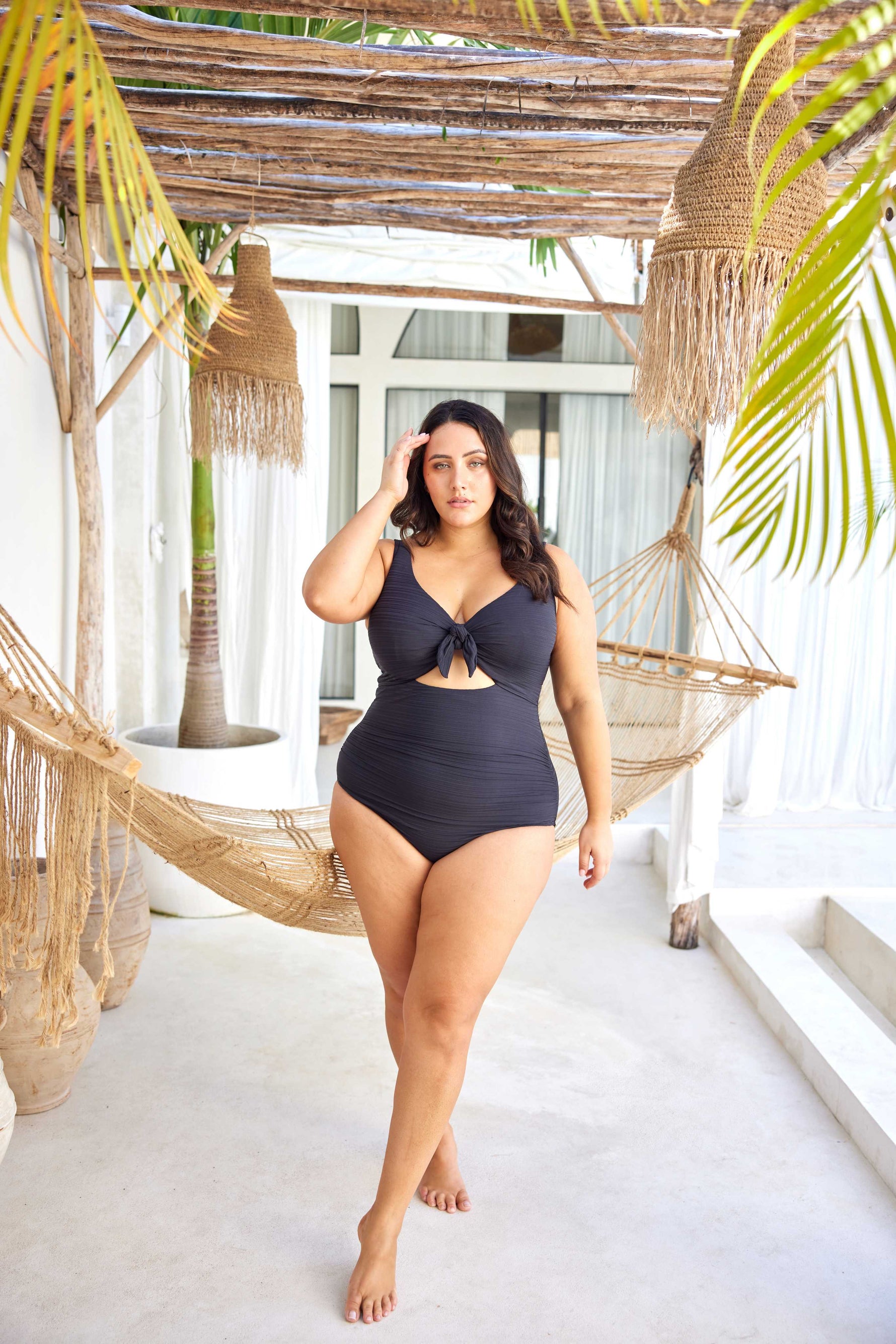 curvy traveler from New York City is enjoying a luxury winter escape in St. Barts, wearing the Aria Black Cezanne tummy control plus size underwire swimsuit, chosen for its premium shaping, luxury underwire lift, best support for sagging breasts, and sophisticated designer cutout design. She loves how this swimsuit enhances her waist and bust, giving her a sleek upscale resort look. Women from Montreal, Vancouver, Houston, and Los Angeles search Sun Vixen Swimwear for best quality plus size bathing suits