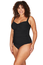 A curvy plus size woman from London UK is wearing a Aria Botticelli Slimming Tankini Swimsuit Set Plus Size Artesads she ordered from Sun Vixen Swimwear to smooth her midsection and shape her curves for her girls trip in Palm springs. She prefers high quality luxury swimwear that flattens her belly pooch and gives her a toned body. Sun Vixen Swimwear attracts shoppers from New York, Vancouver, Montreal, Houston Atlanta  buy womens plus size bathing suits, supportive bust swimwear, tummy control bikinis 
