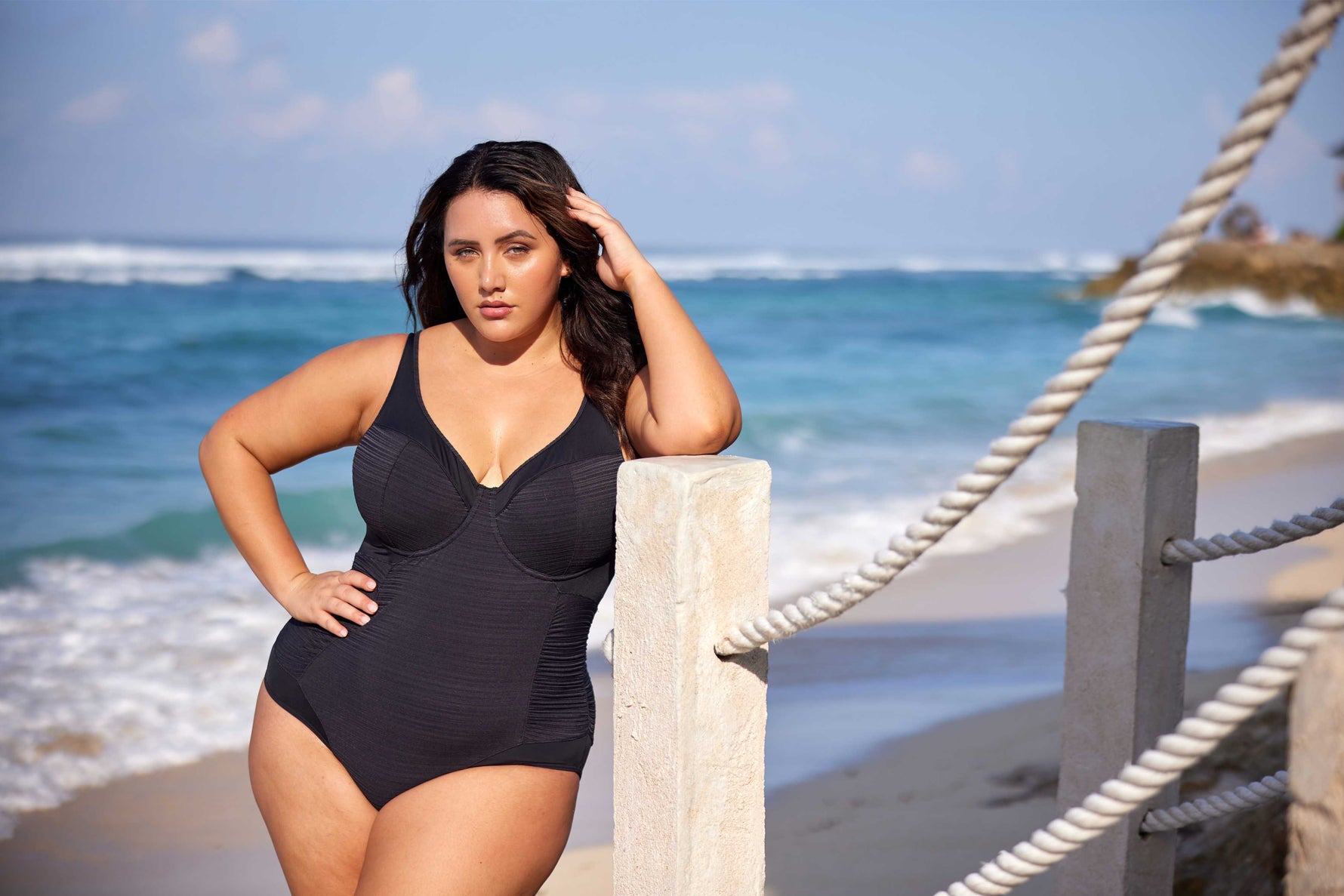 A curvy woman from Miami is spending her birthday weekend in Cabo San Lucas, wearing the Plus Size Aria Giotta Artesands tummy control luxury underwire swimsuit, selected for its premium shaping power, full coverage support, curvy flattering design, and elegant upscale swimsuit perfect for luxury resort settings. This high fashion cut out swimsuit smooths her midsection and lifts her bust with its supportive design. Sun Vixen Swimwear shoppers from Toronto, Vancouver, Houston, San Diego choose this swimsuit