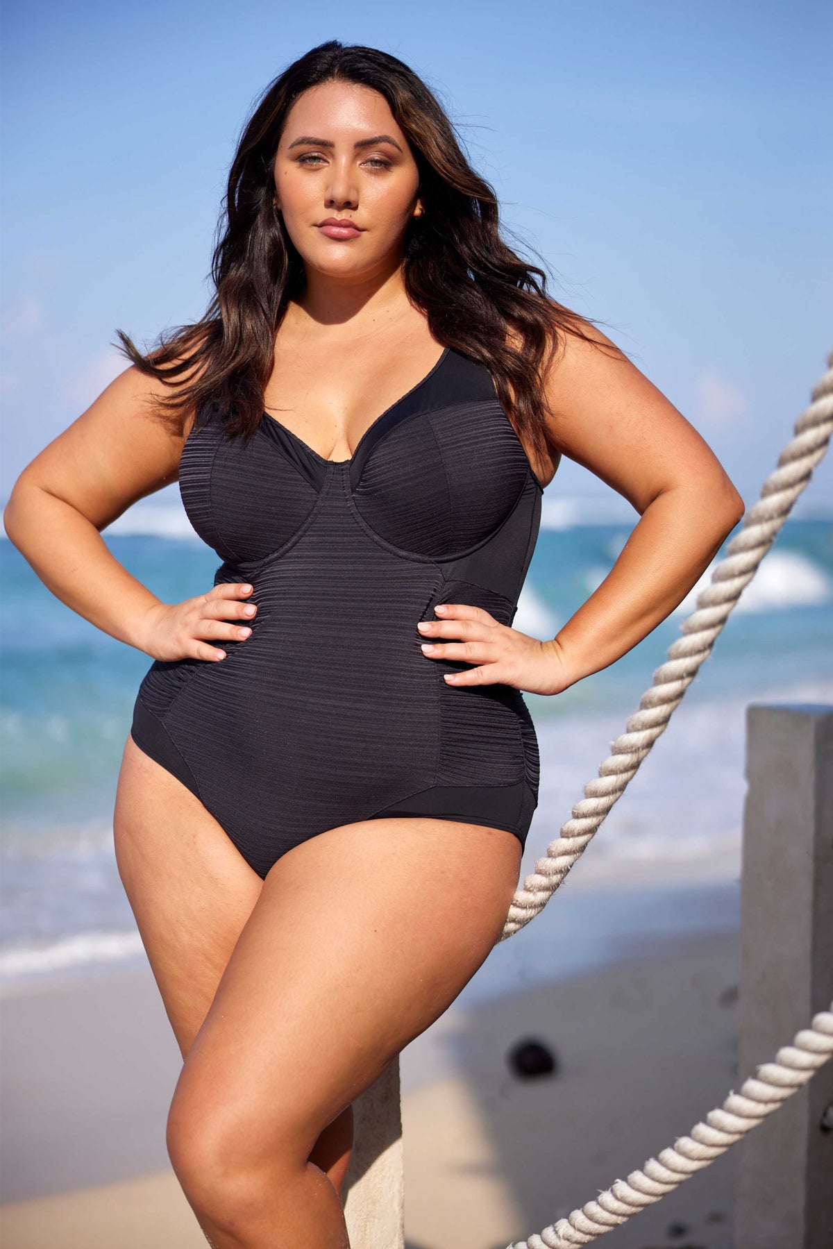 A curvy traveler from Chicago is unwinding at a beach villa in Antigua, wearing the Plus Size Aria Giotta Artesands premium tummy control underwire swimsuit, selected for its premium sculpting, curvy-enhancing shape, supportive lift, and high end designer finish. She enjoys the swimsuit’s soft structure and elegant contouring as she lounges poolside. Women from Vancouver, Miami, Toronto, Los Angeles, Canada USA search Sun Vixen Swimwear for womens swimwear, best quality compression swimsuits online boutique
