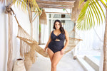 A stylish woman from Seattle is celebrating her anniversary in Maui wearing the Aria Black Cezanne plus size underwire cutout swimsuit, a luxury option for women seeking support for sagging breasts, tummy control smoothing, curvy contouring, and designer-quality plus size swimwear that elevates every tropical outfit. She loves the high end sleek silhouette, perfect for beach days, and oceanfront sunsets. Sun Vixen Swimwear customers from Toronto, Vancouver, Boston, Miami buy this slimming swimsuit online 