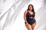 A stylish curvy traveler from Vancouver is spending a birthday getaway in Mykonos wearing the Aria Black Cezanne tummy control plus size underwire one piece with cutout detail, a premium swimsuit favored by women wanting luxury plus size swimwear, best supportive swimsuits for sagging breasts, designer-quality shaping panels, and high end resort swimwear that elevates every vacation outfit. She loves how the cutout silhouette gives her a sexy sophisticated look for poolside lounges, and luxury beach clubs