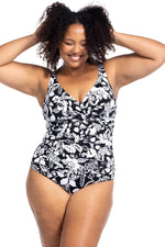 A plus size woman from Los Angeles USA is wearing the Artesands Cantata Forte Black Delacroix black floral one piece swimsuit, choosing it for its strong tummy control, slimming fit, shapewear support, plus size compression, high quality designer swimwear. She bought this luxury curvy ladies swimsuit from Sun Vixen Swimwear USA Canada, known for supportive elegant resort swimwear, flattering sculpting swimwear, classy high end premium bathing suits online. She’s packing it for her trip to Cabo San Lucas  