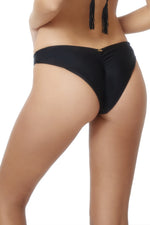 a stylish woman from Boston on her tropical vacation wearing a sexy black bikini and cheeky bikini bottoms PQ Swim Midnight Basic Ruched Bottoms teeny she purchased online from swimwear fashion boutique website. This fashion enthusiast travels and shop online for hot celebrity swimsuits for vacations, best bikinis, glamorous swimwear, bombshell bikinis on sun vixen swimwear a top rated swimwear website on google with 5 star ratings popular for best name brands swimsuits, designer bikinis in USA and Canada