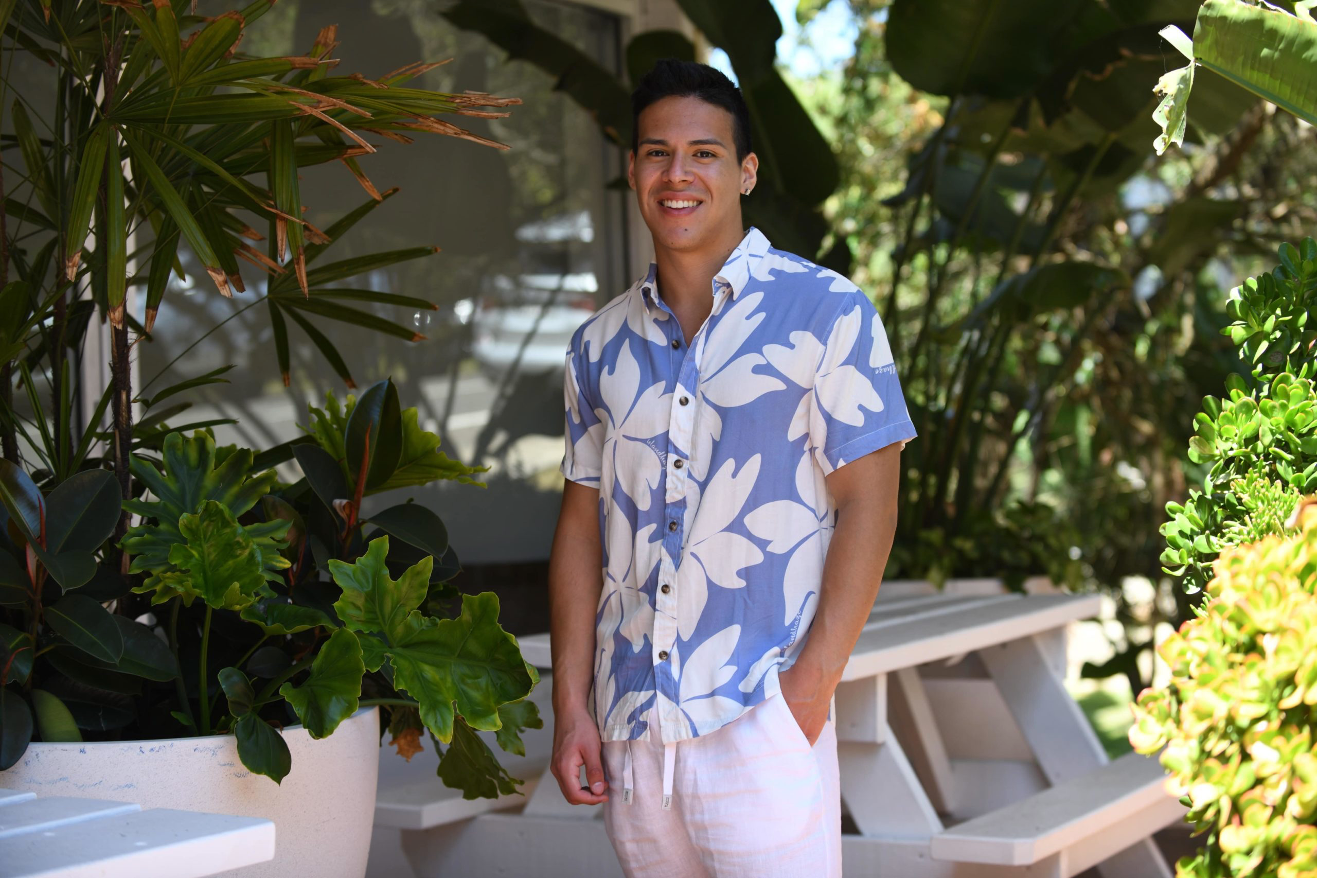 A stylish man wears a designer Hawaiian beach shirt from Sun Vixen Swimwear on a tropical vacation. This mens designer swimwear store offers the best luxury beach shirts, featuring floral beach shirts, designer mens beachwear, and premium resort shirts, perfect for a smart resort  beach look. This mens designer swimwear store features the best luxury beach shirts, cool beach shirts, sustainable mens beachwear, and tropical shirts, stylish resort shirts, and stylish resort shirts, high end designer beachwear