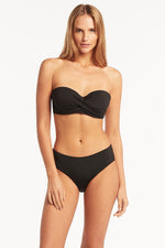 Eco Essentials Twist Front Bandeau underwire push up bikini top made by sea level Australia worn by a lady from Philadelphia USA with Eco Essentials Mid Bikini Pant sustainable mid rise bikini bottoms. Who shops online for supportive strapless swimsuit designed with double push up bikini pads on sun vixen swimwear Edmonton. Luxury shoppers in Windsor, Bakersfield. Buy classy black bikinis with ruching and boning full coverage bikini bottoms with tummy control fabric. Buy luxury shaping swimwear USA Canada