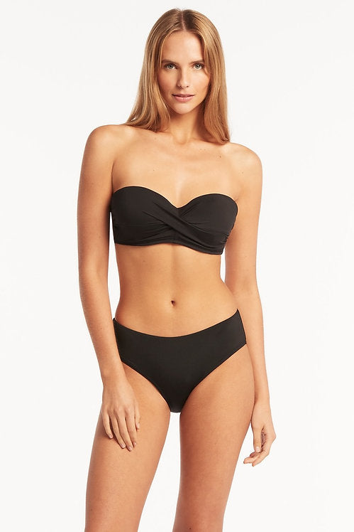 Eco Essentials Twist Front Bandeau underwire push up bikini top made by sea level Australia worn by a lady from Philadelphia USA with Eco Essentials Mid Bikini Pant sustainable mid rise bikini bottoms. Who shops online for supportive strapless swimsuit designed with double push up bikini pads on sun vixen swimwear Edmonton. Luxury shoppers in Windsor, Bakersfield. Buy classy black bikinis with ruching and boning full coverage bikini bottoms with tummy control fabric. Buy luxury shaping swimwear USA Canada