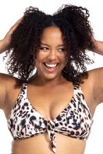 A woman from Nashville Tennessee is on her Caribbean cruise wearing Artesands saphare chagall leopard bikini top enjoying the smoothing supportive tummy control design while relaxing on the ship deck. She bought her high end womens swimwear, animal print bikini from Sun Vixen Swimwear best boutique online carrying luxury compression bikinis, glamorous plus size swimsuits, shapewear bathing suits, high quality tummy toning swimwear, fashionable ladies bikinis with fast shipping across Canada USA worldwide