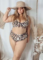 A curvy woman from San Jose California is on her Maldives getaway wearing Artesands saphare chagall leopard bikini bottoms paired with a underwire animal print leopard bikini top. She chose these mid rise tummy control compression bikini bottoms and supportive swimsuit top for the way they cinch her waist so she looks slimmed and toned. She bought them from Sun Vixen Swimwear a luxury womens swimwear boutique online known across Canada and USA for best plus size bikinis, flattering good quality bathing suit