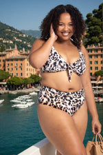 A woman from Austin Texas is on her week long Cabo vacation wearing Leopard Bikini Bottoms Artesands saphare chagall with a matching animal print bikini top. She loves the mid rise tummy control fit because it smoothes her waist with good quality compression fabric for long beach days. She always shops Sun Vixen Swimwear online boutique for sustainable designer womens swimwear, tummy control bikinis, good quality luxury compression swimsuits, sophisticated animal print bathing suit across Canada and the USA