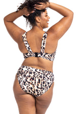 A woman from Houston is on her Aruba trip in her Artesands saphare chagall leopard bikini bottoms loving the tummy control mid rise bikini bottoms that smoothes and sculpts her curves. This high end plus size woman shops Sun Vixen Swimwear online boutique for premium plus size swimsuits, stylish animal print bikinis, designer womens swimwear trusted in Canada USA in cities Toronto Chicago Edmonton New York Seattle Mississauga for luxury flattering swimsuits and best swimsuits for bigger sagging bust support