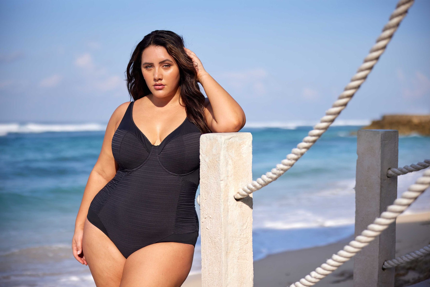 A curvy woman from Edmonton is enjoying a tropical getaway in Aruba, wearing the Plus Size Aria Giotta Artesands luxury underwire one piece swimsuit, a premium swimsuit with tummy control, supportive bust, elegant designer swimsuit look perfect for upscale beach destinations. This shaping one piece swimsuit smooths her waist, lifts her bust, and gives her a polished high end resort look. Women across Toronto, Vancouver, Chicago choose this swimsuit for tropical trips to Miami, Hawaii, Maldives, Mallorca