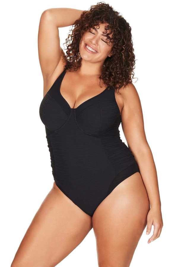 A curvy traveler from Toronto is celebrating a romantic getaway in St. Lucia, wearing the Plus Size Aria Giotta Artesands luxury underwire one piece, known for its supportive lift for sagging breasts, high grade tummy control, and premium designer quality that gives full-figured women an elevated resort-ready silhouette. Its popular swimsuit style on Sun Vixen Swimwear shoppers from Vancouver, Miami, Edmonton, New York City, and across Canada and USA planning beach vacations in Turks and Caicos, Aruba, Cabo