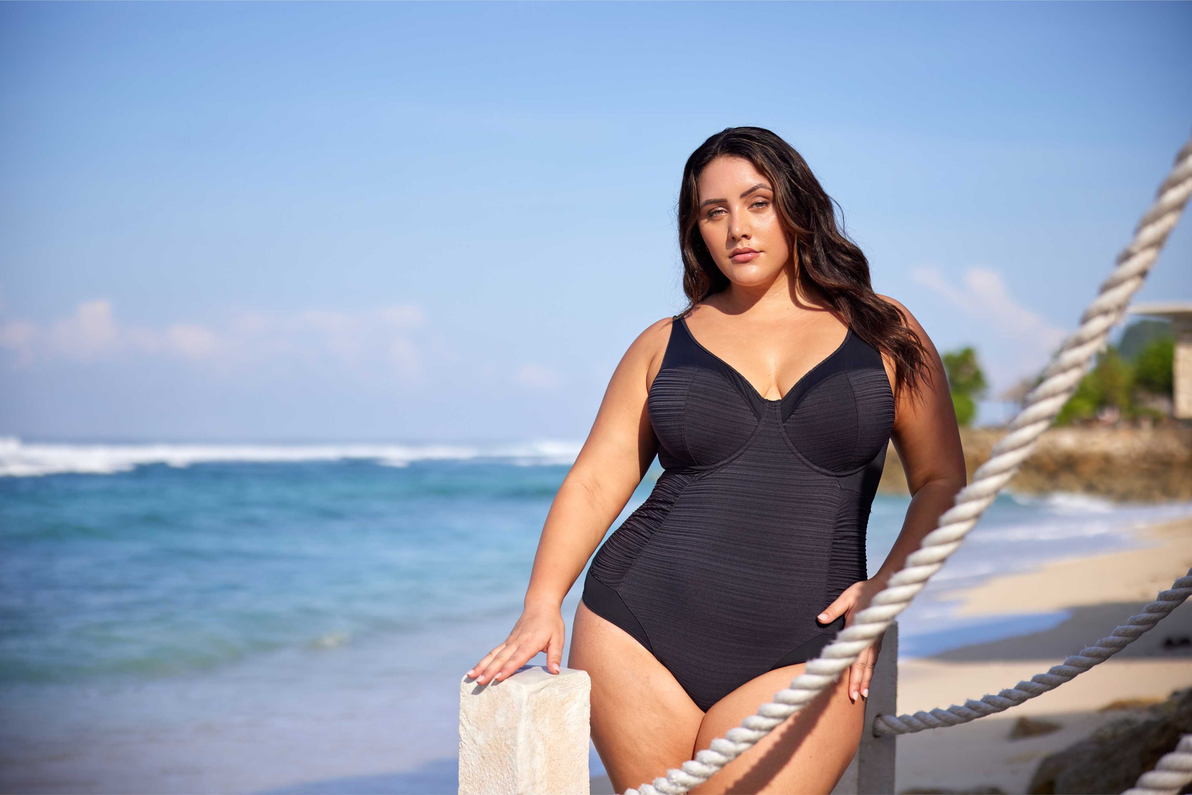 A stylish curvy woman from San Diego is enjoying a luxury hideaway in St. Barts, spending wearing the Cut out swimsuit Plus Size Aria Giotta Artesands premium underwire swimsuit, selected for its premium tummy control, curvy shaping, supportive underwire lift, and designer high end quality that gives a sleek, refined silhouette. She lounges at Nikki Beach, wearing slimming swimsuit that hides her belly pooch and supports her bust with lift for sagging breasts design. Travelers from Montreal, Houston shop 