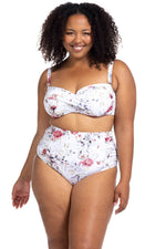 A curvy traveler from New York USA wears the Clementine White Botticelli High Waist Bikini Bottoms on her luxury trip to St. Lucia, choosing these flattering ruched plus size bikini bottoms because they contour her waist and offer a smooth, sculpting fit. She loves how elegant and classy the white floral bikini looks on a beach holiday She bought them from Sun Vixen Swimwear, a boutique known for the best plus size swimwear in Canada and the USA, for women who want compression bathing suits, bikinis online