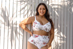 A curvy woman from Montreal Canada packs the Artesands Clementine White Botticelli Ruched High Waist Bikini Bottoms for her romantic vacation in Santorini, wanting a sexy yet supportive plus size bikini that enhances her waist and feels luxurious on island. She loves the soft touch and sculpting effect that makes these bikini bottoms one of the best plus size swimwear style in Canada USA. She purchased them from Sun Vixen Swimwear, choosing the boutique for its high quality slimming womens designer swimwear