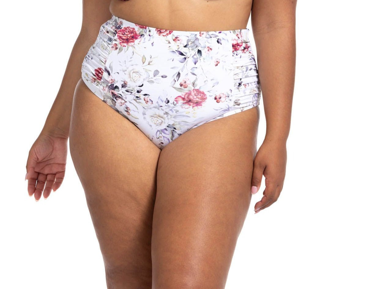 A plus size woman from Vancouver Canada is lounging by her rooftop pool before her trip to Tulum, wearing the Artesands Clementine White Botticelli High Waisted Ruched Bikini Bottoms paired with her favorite supportive bikini top. She loves how these slimming, flattering plus size bikini bottoms shape her curves with compression fabric and elegant ruching. She discovered them on Sun Vixen Swimwear, a luxury boutique known for the most flattering bikinis for plus size women online Los Angeles Toronto, Miami