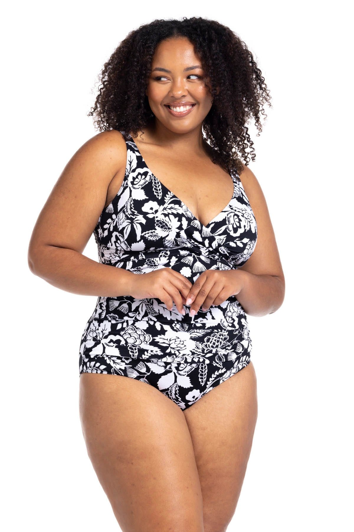 A plus size woman from Chicago USA is wearing the Artesands Cantata Forte Black Delacroix floral one piece swimsuit for its high quality tummy control, shaping fit, supportive bust design, slimming compression, luxury curvy swimwear. She ordered it from Sun Vixen Swimwear USA Canada, known for best shapewear swimsuits, premium flattering bathing suits for plus size women, elegant high end designer swimwear. She’s taking it to Mykonos, where travellers want sculpting swimsuits, luxe plus size resort swimwear