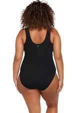 A plus size woman from Dallas USA wears the Artesands Natare Fuseli Zip One Piece to her luxury resort in Cancún, choosing the black tummy control swimsuit because it gives her that sculpted hourglass shape. She purchased this designer curvy swimwear from Sun Vixen Swimwear USA Canada, known for high end flattering swimsuits for women who appreciate quality, support, and elegance. Shoppers from Edmonton and Quebec City also love this piece swimsuit for upscale vacations in Santorini and Turks and Caicos