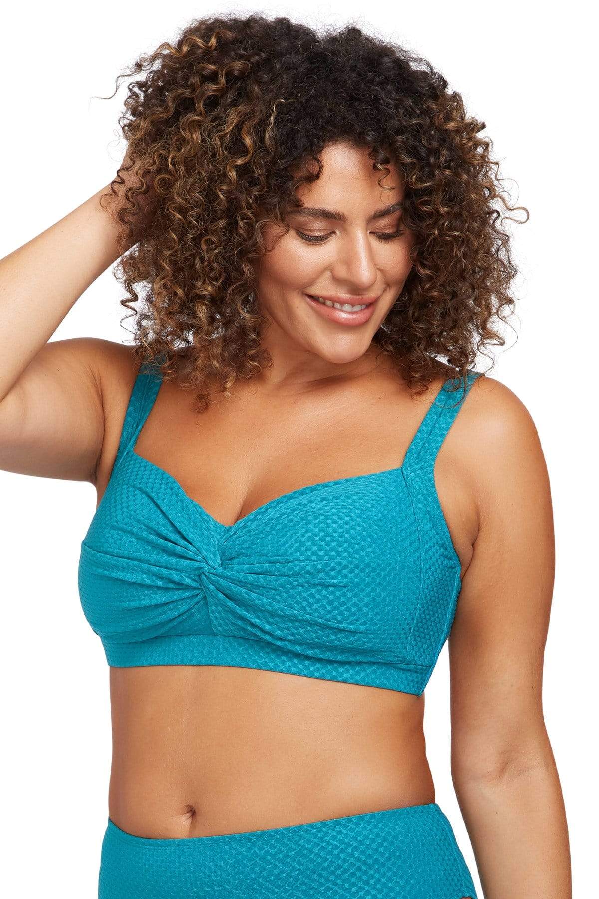 A plus size woman from Vancouver Canada is walking along her beachfront hotel pool in the Rhapsody Teal Botticelli underwire bikini top and high waist tummy control bikini bottoms by Artesands, choosing this sophisticated designer set for its sleek smoothing fit. She purchased it from Sun Vixen Swimwear Canada because she wanted the best curvy ladies swimwear and classy plus size swimsuits for her tropical holiday. She loves sexy slimming swimsuits that make her feel confident, elegant, and high fashion