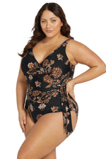 A plus size woman from Seattle USA is wearing the black one piece swimsuit tummy control Plus Size Chantique Hayes D/DD Cup Underwire swimsuit while relaxing at a boutique resort in Turks and Caicos, choosing this black floral swimsuit for its structured tummy control, supportive underwire lift, and slimming curvy silhouette that feels luxury without and elegant. She prefers high quality slimming swimwear, gorgeous plus size resort swimsuit, and designer one pieces that make her feel glamorous for pool trip