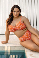 A plus size woman from Miami is wearing the Copper Monet soft cup underwire bikini cheetah print bikini set from Artesands with high waist tummy control bikini bottoms she ordered from sun vixen swimwear usa canada for her luxury beach vacation. She loves the supportive fit that smooths her curves and gives her a sexy slimming silhouette for her poolside vacation. This designer plus size swimwear is one of the most flattering swimsuits for curvy women who want classy look and bold animal print bikini style