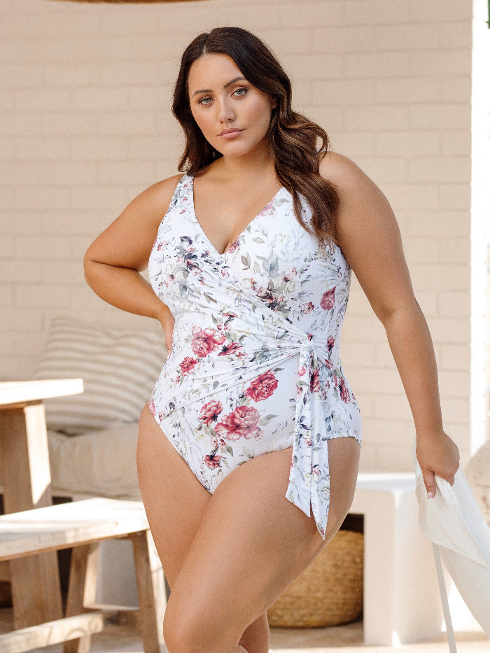 A woman from Montreal is celebrating a romantic getaway in Riviera Maya wearing the Artesands Clementine White Hayes plus size wrap one piece underwire swimsuit, a favourite for women needing supportive swimwear for sagging breasts, luxury tummy control, designer shaping panels, and premium quality curvy beachwear. She orders from Sun Vixen Swimwear because the swimsuit delivers a sophisticated, upscale, high end resort look. This style is popular among shoppers from Vancouver, Los Angeles, Miami, Chicago