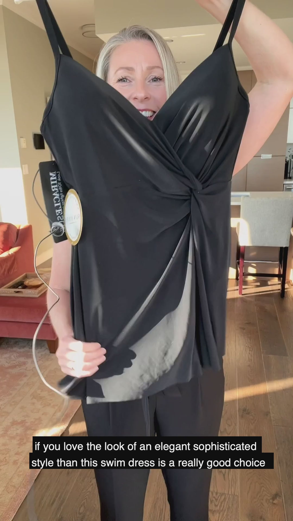 flattering compression black slimming swim dress designer made by miraclesuit for unmatched tummy control in fancy upscale elegant one piece swimwear with knotted front ruched detail that cinches the waist for hourglass effect while good cleavage draws eyes up lengthening the body of the glamorous woman wearing this stunning and stylish swim dress. Quality fabric stands up over time with many seasons of wear and comes in a timeless fashionable cut that will stay in style. simplicity in statement swimwear