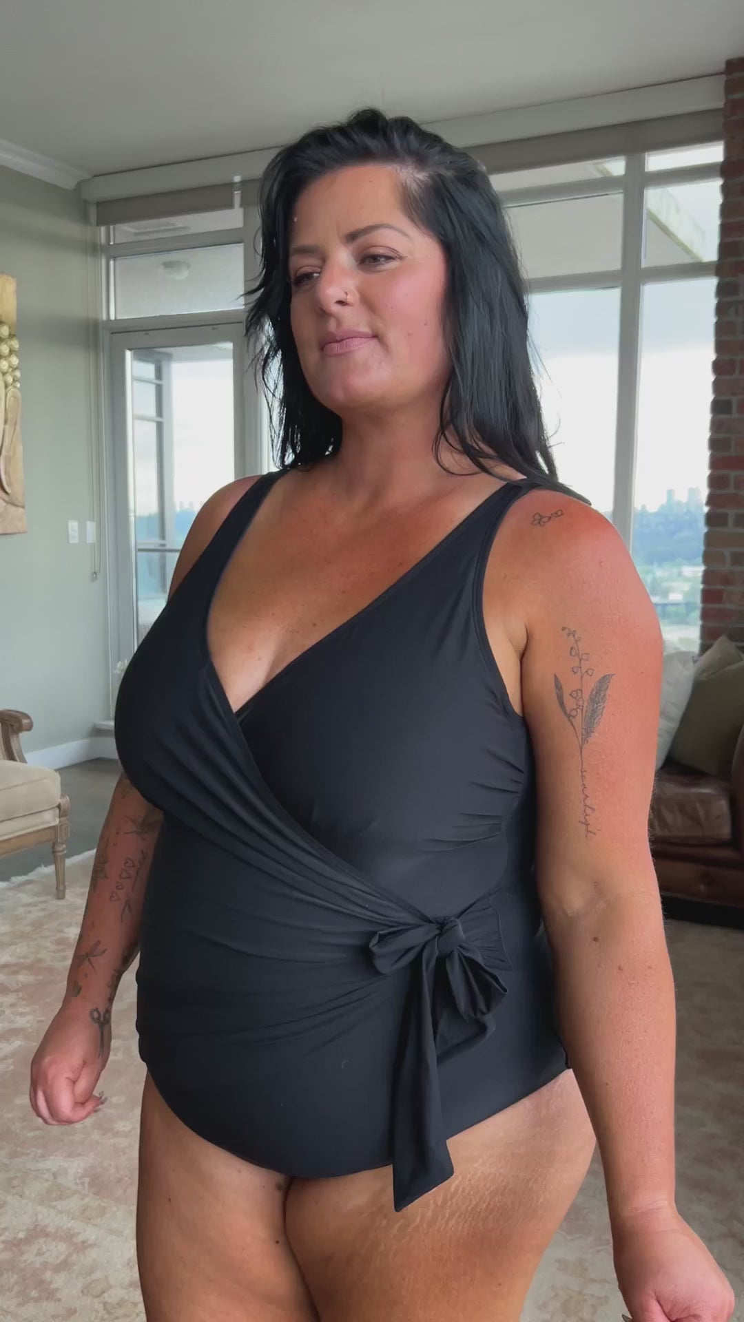 A curvy traveler from Miami walks along the resort pool in her Black Artesands Hayes Underwire One Piece Swimsuit feeling the firm tummy control and luxe slimming fit shaping her waist. She loves this classy black one piece swimsuit for its wrap front detailing and high quality designer finish that elevates her whole look. She shops luxury plus size swimwear, luxury womens swimsuits online and chose this high end flattering bathing suit to feel confident elegant sophisticated for her luxury Miami holiday