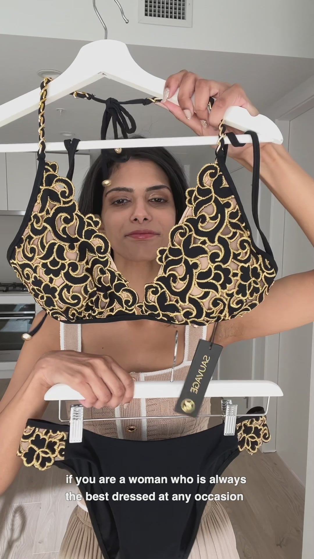 black and gold bathing suit luxury designer made in the USA by Sauvage. Unique bikini is made to look similar to fancy lingerie with cutout look and beige skin tone underlay for a fashionable nude effect look. Fully lined so it is not see through. Removable pads for a classy look. Gold chain embellishments on the halterneck of this bikini top elevate your vacation look. Bottoms are full coverage with laser cut sides of black and gold to match the bikini top. Designer celebrity luxe style bikini look sexy 