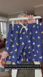 Banana Swim Trunks Island Haze Tropical print Mens Shorts cool print funny shorts navy blue 5 inch inseam elastic waist drawstring front inner mesh lining side pockets back velcro close pocket quick dry soft fabric unique lucky banana swim short lively print vacation beach vibe vacation hilarious couples trip joke ridiculous guys blue navy unusual popular best mens swim good price ships fast buy canada usa alaska mexico detroit PG travel online shopping enthusiast beauty maven gym goer travels often joker