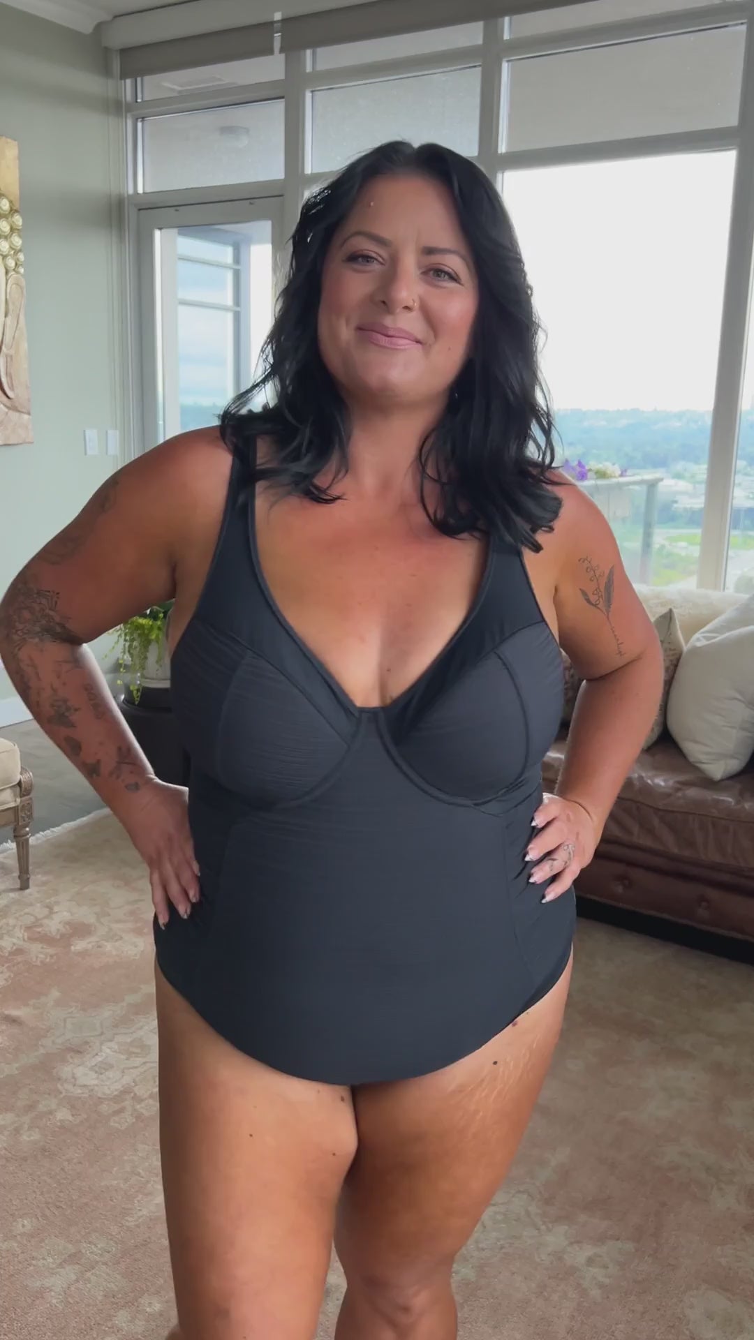 A woman from Los Angeles is celebrating her birthday in Aruba, wearing the Plus Size Aria Giotta Artesands premium tummy control underwire one piece swimsuit, a luxury bathing suit known for its high quality shaping, soft yet supportive structure, and full bust lift for sagging breasts, giving curvy women an elegant and elevated silhouette for upscale vacations. She loves how this swimsuit smooths her tummy, contours her waist, and enhances her bust, making her feel graceful elegant on beach vacation 