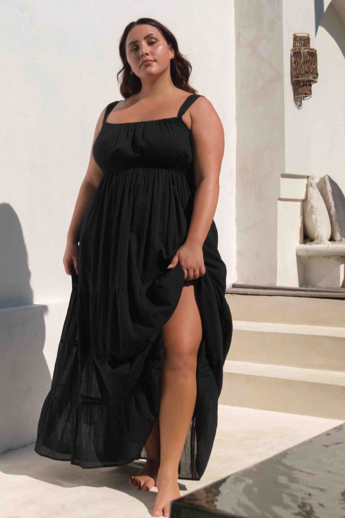 A plus size traveler from San Diego is exploring Mykonos in her black Liszt long maxi beach cover up, top rated style for women searching for luxury black beach cover ups, classy plus size vacation dresses, designer resort wear, and high end beach outfits. Sun Vixen Swimwear curated this item for stylish curvy travelers who want elegant, well made designer swimsuits for beach trips, island vacations, and luxury resort stays. This cover up trends among shoppers looking for popular plus size beach cover ups