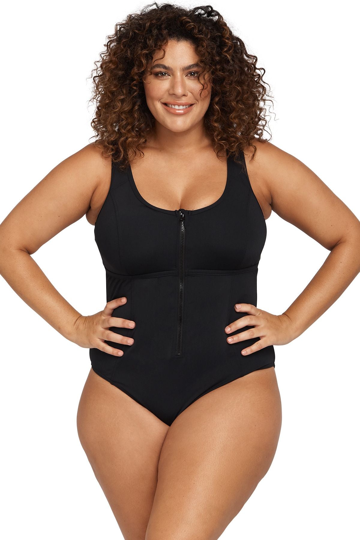 Confident curvy woman in Chicago USA is relaxing in the spa lounge wearing the Artesands Natare Black Chlorine Resistant Fuseli Zip One Piece, a luxury plus size swimsuit known for its shaping and best tummy control fit. She’s shopping for her girls trip to Maldives, and she wanted a sexy but classy designer one piece swimsuit that looks beautifully on high end beach vacations. She ordered it from Sun Vixen Swimwear, the boutique she trusts for high quality slimming swimwear that slims tones belly pooch