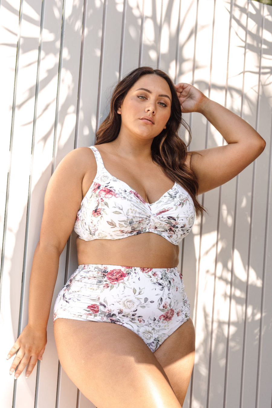 A curvy woman from Los Angeles USA is wearing the Artesands Clementine White Botticelli high waisted ruched bikini bottoms she ordered from Sun Vixen Swimwear, loving how the plus size supportive bikini smooths her waistline for her vacation in Maui Hawaii. She’s lounging at a luxury resort pool feeling confident in the most flattering bikinis for plus size women, enjoying the compression and slimming fit. This elegant designer swimwear is perfect for curvy ladies who want a sexy, classy, tummy control look