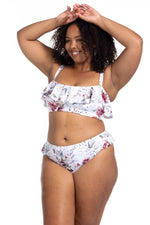 A plus size woman from Edmonton Canada shopped Artesands Clementine White Vermeer frilly flounce bikini top with white floral aesthetic for her pool day paired with high waist shaping bikini bottoms flattering tummy control. She bought it from Sun Vixen Swimwear Canada USA also purchased cute ruffle bikinis, sexy plus size swimwear, and the most flattering bikinis for bigger women online with luxury finishes. She loves the sleek feminine style it brings to her vacation wardrobe. Buy compression bikinis now 