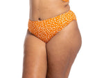A plus size traveler from Sydney is sunbathing at a beach club wearing her Copper Monet cheetah print bikini set plus size with supportive underwire soft cups and high waist slim shaping bikini bottoms. She purchased it from sun vixen swimwear usa canada she loves designer curvy swimsuits that fit beautifully and offer tummy control shape. She feels stylish and relaxed as she enjoys her day in the sun, knowing she looks elegant and confident. The bold animal print bikini adds flair to her resort wardrobe