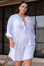 A curvy traveler from Miami is relaxing at a beachfront hotel in Mykonos wearing the Artesands white Gershwin over shirt beach cover up, choosing this piece because it’s the classiest luxury white cover ups, best beachwear shirt cover up, high end bikini cover ups for stylish resort trips. She shops at Sun Vixen Swimwear for designer vacation outfits, classy sexy cover ups, and popular resort wear that looks sophisticated on island vacations. This white beach cover up is popular across Canada USA travelers 